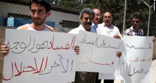 Palestinians take part in a protest outside the ministers council headquarters in the West Bank city of Ramallah on July 19, 2011, calling for the trial of ministers and officials accused of financial and administrative corruption . Photo by Issam Rimawi