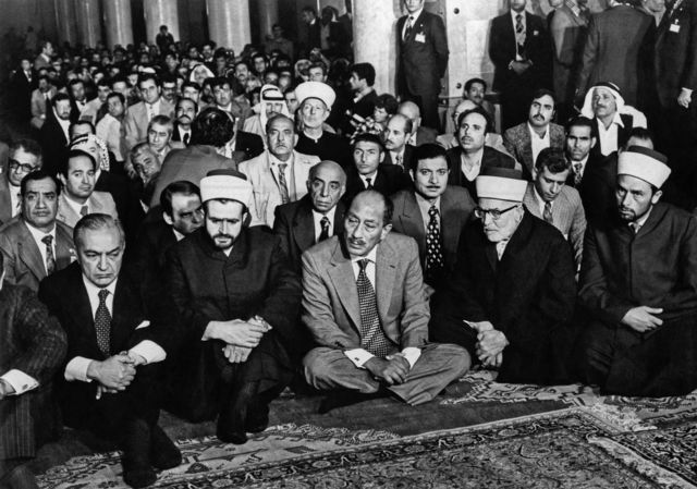 السادات يجلس في المسجد الأقصي وحوله عدد من الشيوخ والوفد المرافق له.