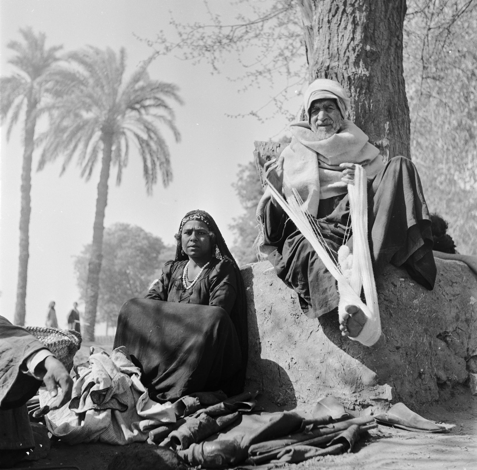 A man twirls cotton into threads using his foot.