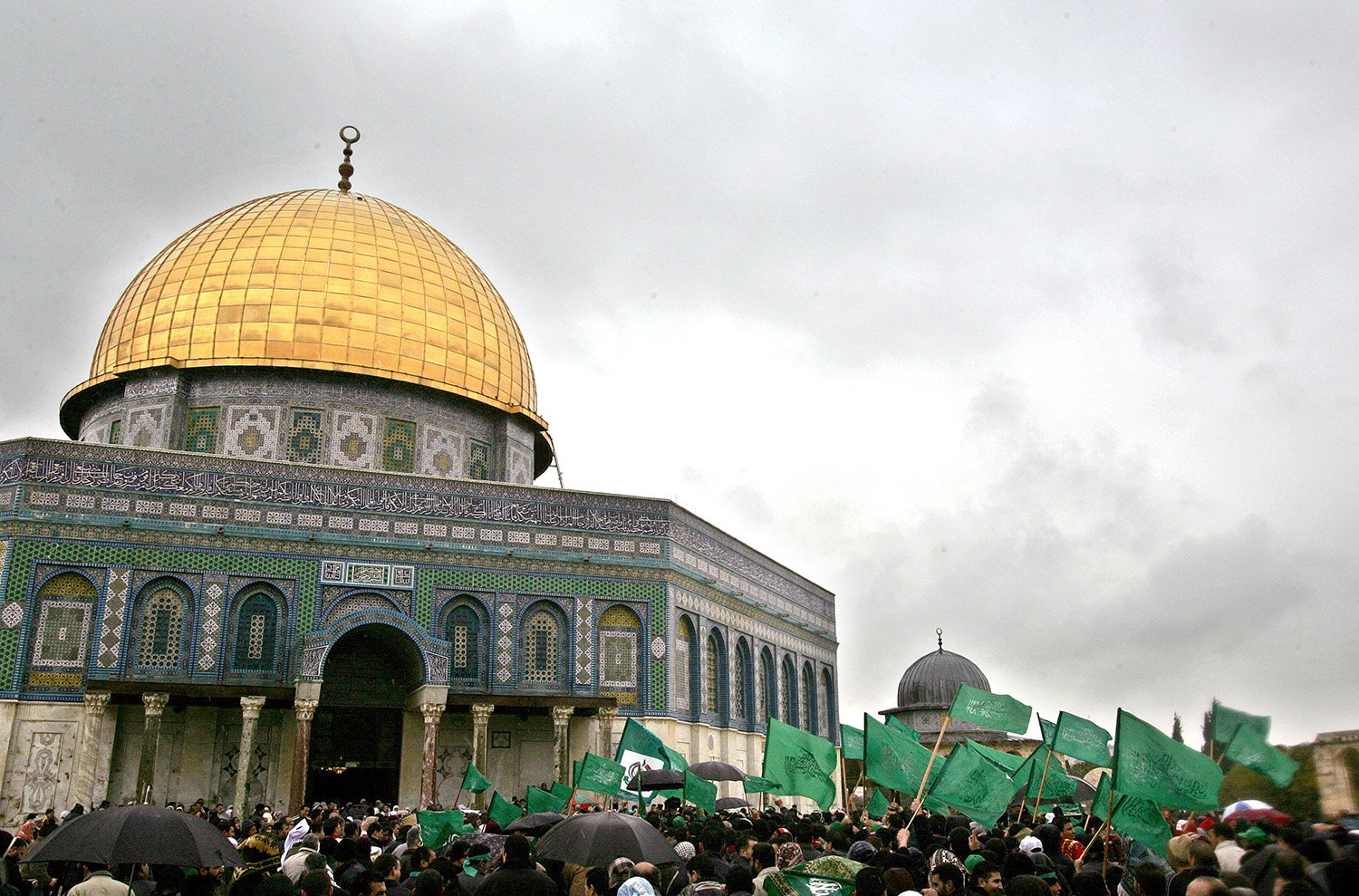 حشد من الفلسطينيين المؤيدين لحماس يلوحون بالأعلام الإسلامية الخضراء بعد صلاة ظهر الجمعة في قبة الصخرة في مجمع المسجد الأقصى في عام 2006.